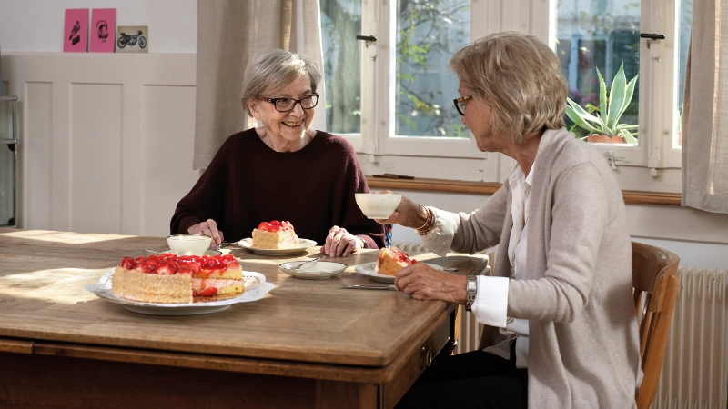 Zwei ältere Frauen am Tisch bei Kaffee und Kuchen